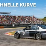DTM-Rennwagen auf dem Nürburgring mit Zuschauertribüne im Hintergrund