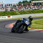 MotoGP-Motorrad in einer der Linkskurven des Sachsenrings mit Zuschauern