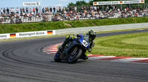 MotoGP-Motorrad in einer der Linkskurven des Sachsenrings mit Zuschauern