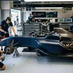 Formel-1-Fahrzeug mit Sponsor-Logos auf der Karosserie in der Boxengasse